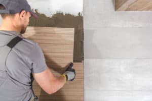 Professional tiler installing tiles over drywall